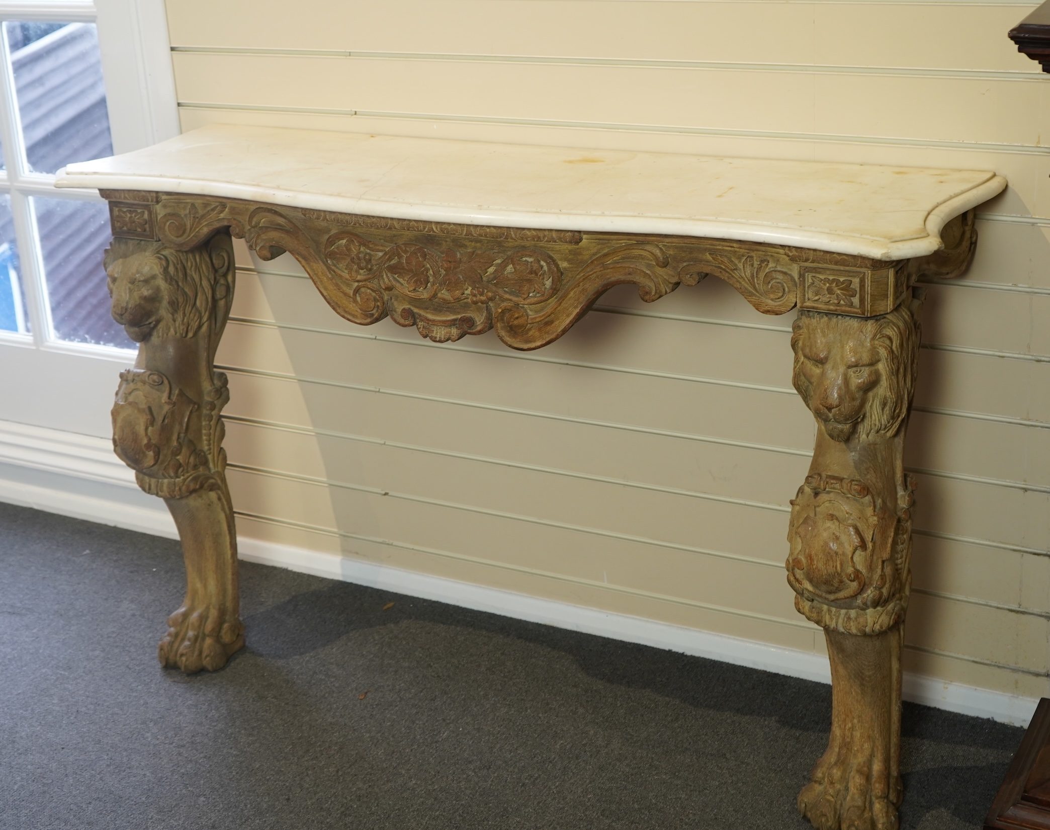 A 19th century Baroque style marble topped limed oak serpentine console table